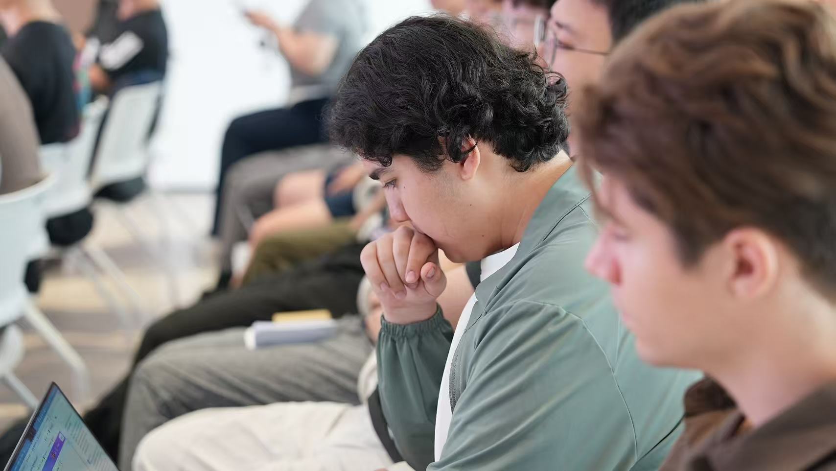 Workshop participants concentrating on a laptop