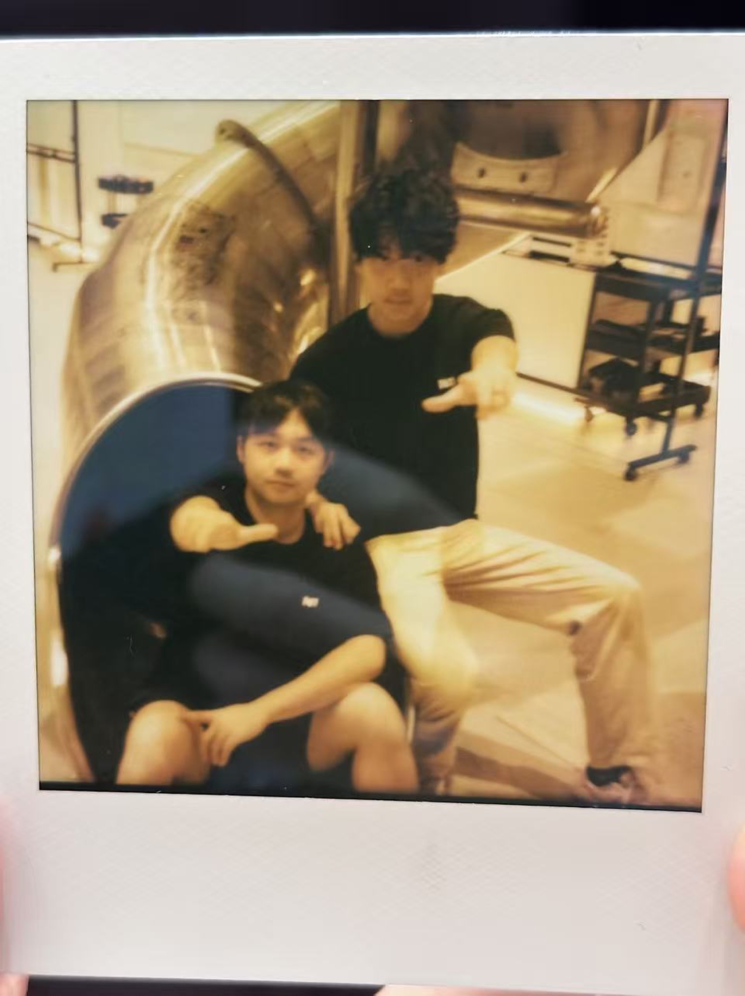 An instant photograph of two friends beside an indoor slide