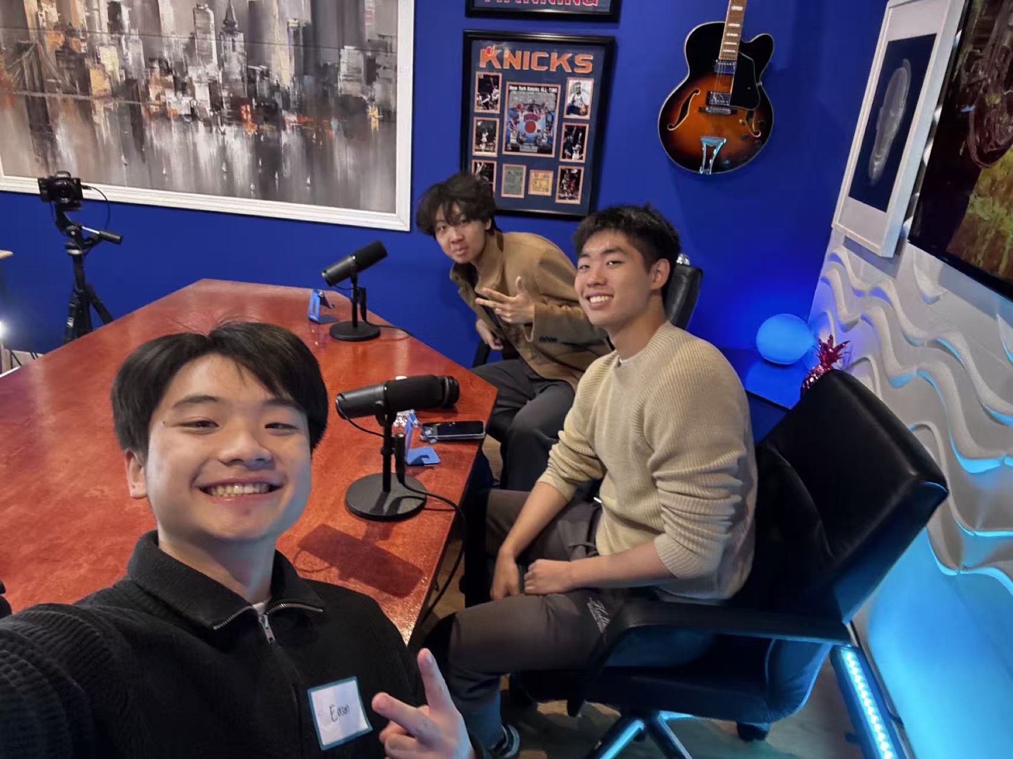 Three friends around microphones in a recording room
