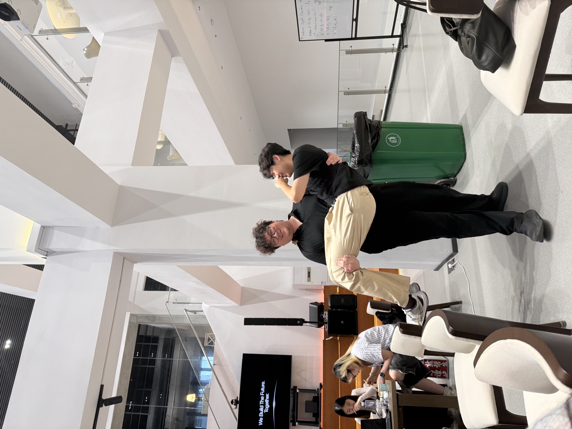 Two friends sharing a playful moment in a bright shared workspace