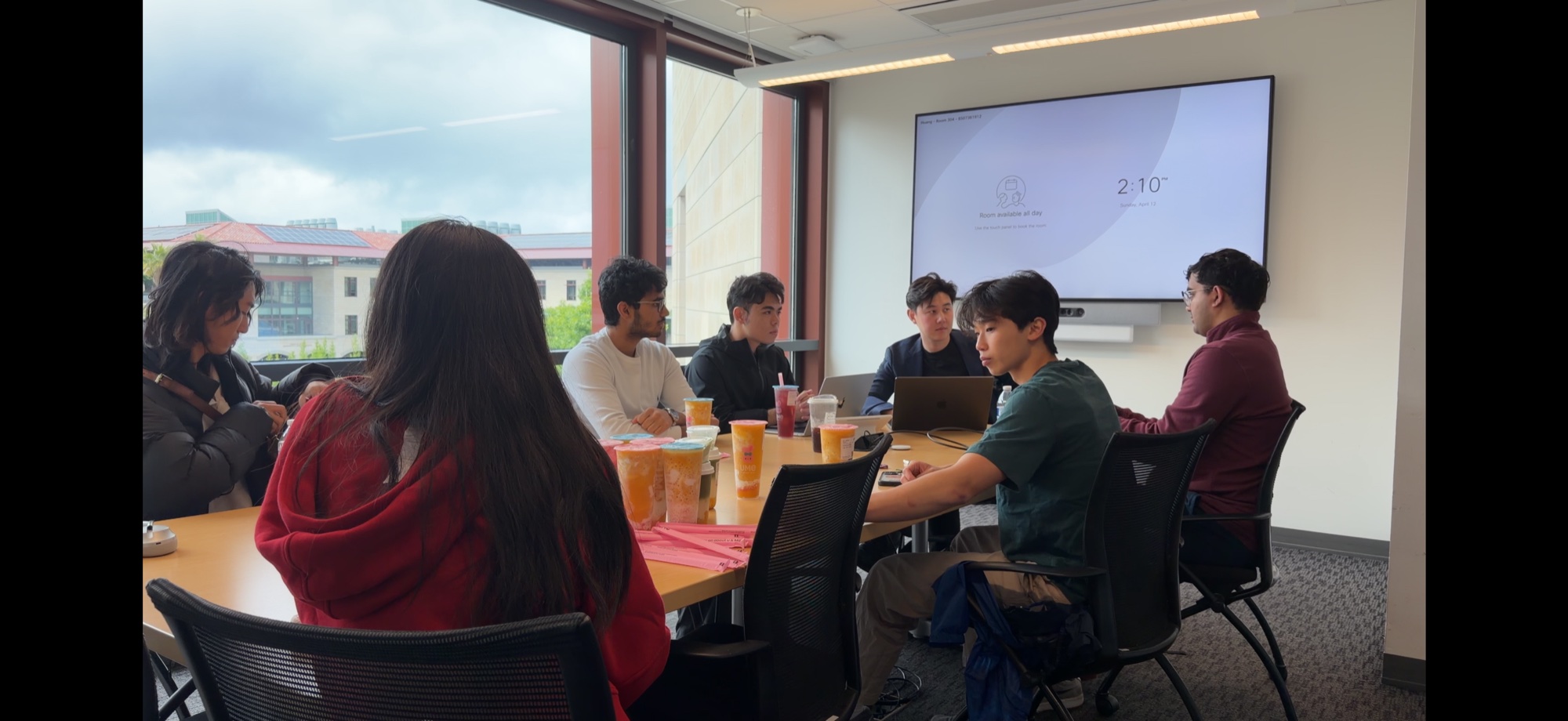 A group sharing ideas around a table with laptops and drinks